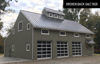 green broken back salt box with three garage bays